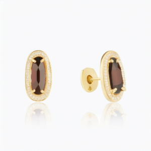 A pair of gold plated flat back earrings featuring oval cut ruby crystals, ideal for helix and cartilage piercings.